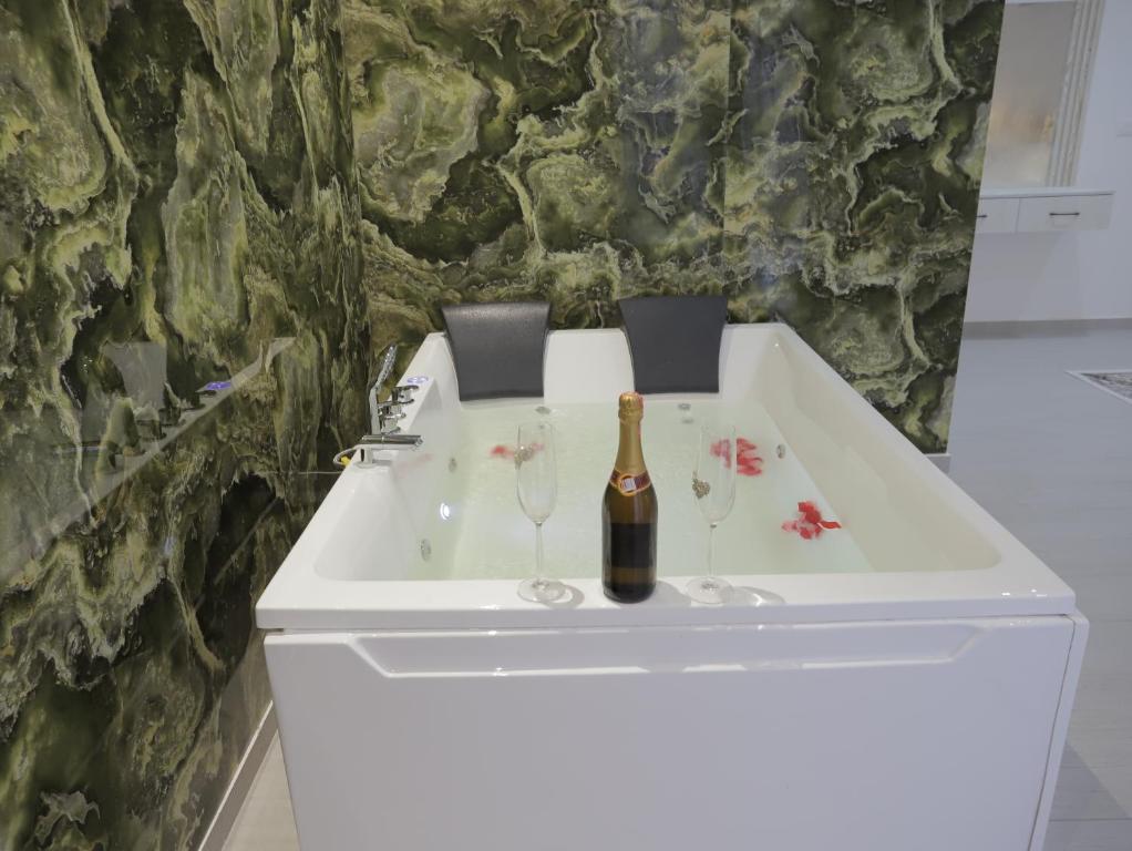 a white sink with a bottle of champagne and wine glasses at Shatri Hotel in Vranisht