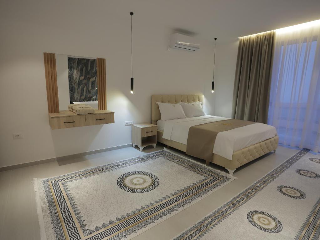 a bedroom with a king sized bed and a rug at Shatri Hotel in Vranisht