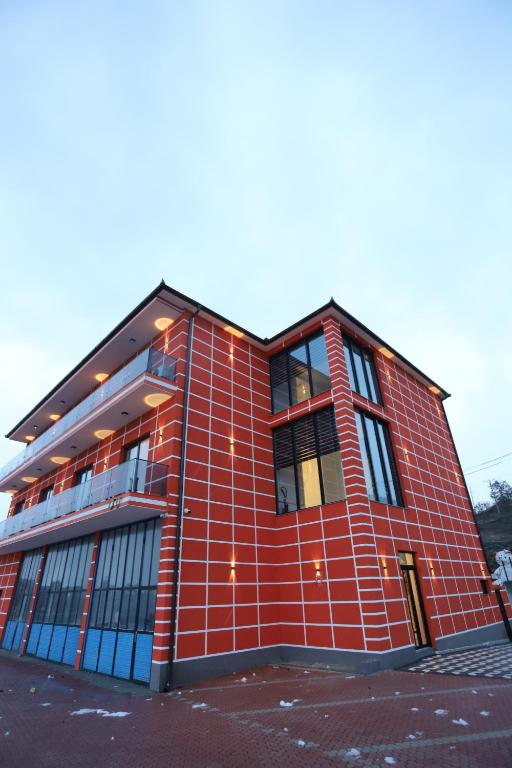 a red brick building with windows on a street at Shatri Hotel in Vranisht