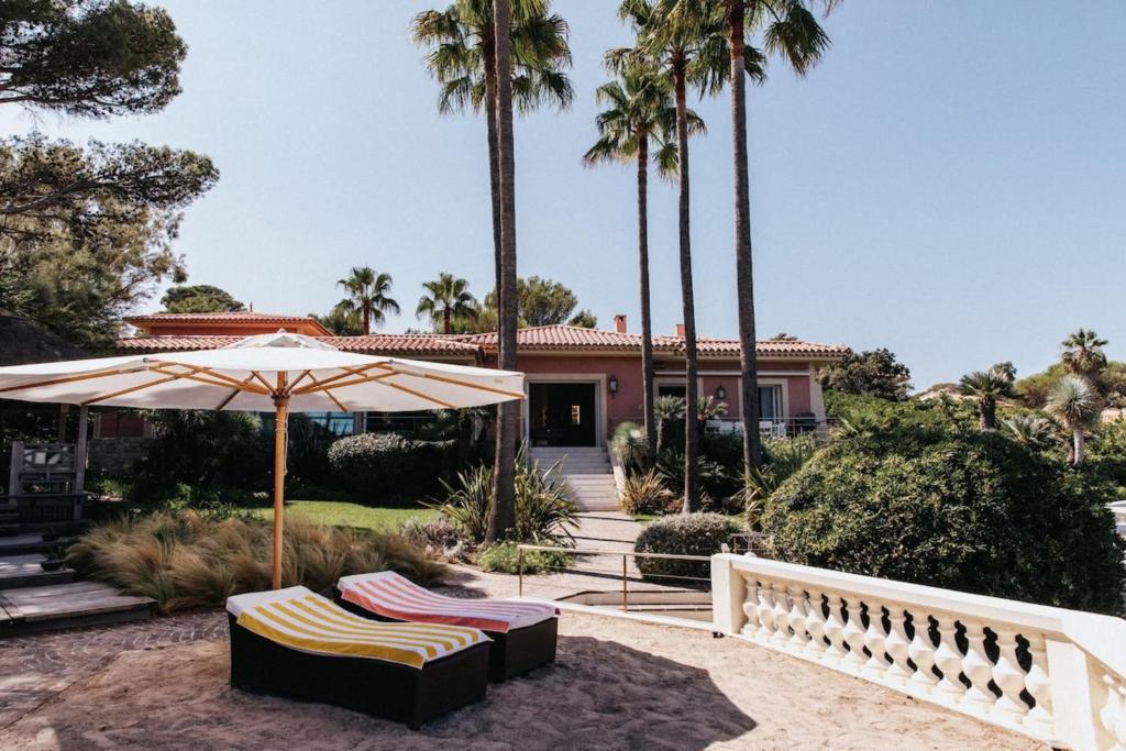 une paire de chaises sous un parasol devant une maison dans l'établissement Villa Camille, à Fréjus