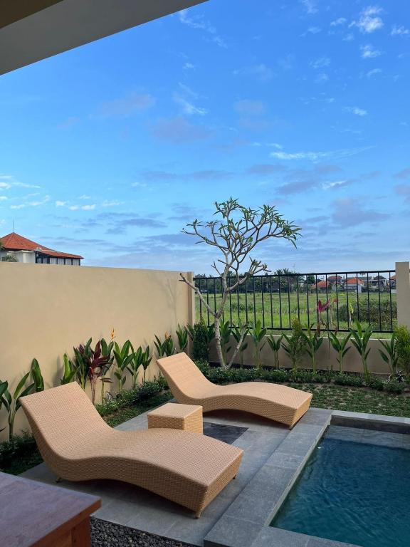 a patio with two chairs and a swimming pool at Villa Lestari in Ubud