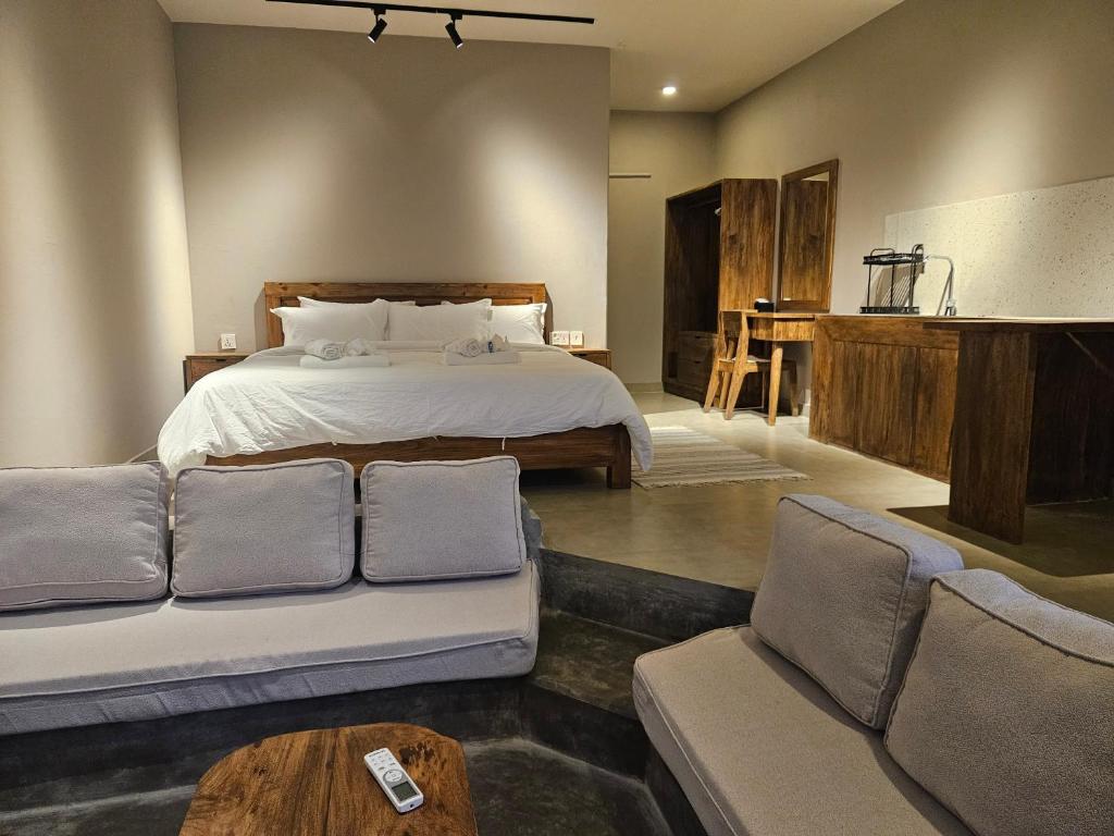 una camera da letto con un letto, un divano e un tavolo di Hotel Blossom a Pokhara