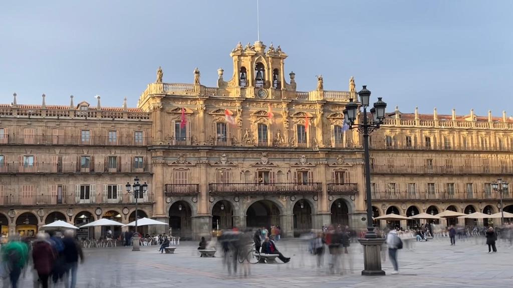 un grande edificio con persone che camminano davanti ad esso di Plaza Mayor de Salamanca Apartamentos a Salamanca