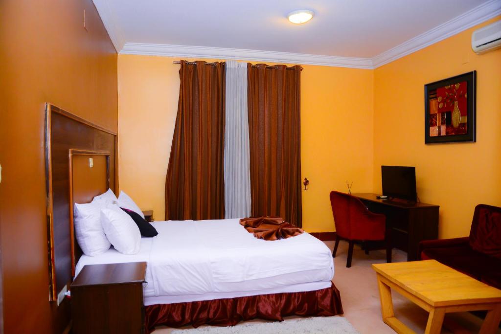a hotel room with a bed and a desk at The Country Inn Hotel in Kigali