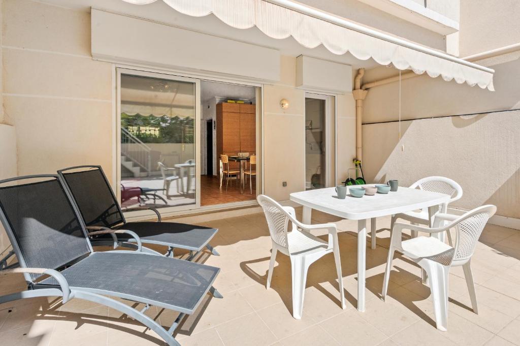 une salle à manger avec une table et des chaises blanches dans l'établissement L'impérial, terrasse, à Menton
