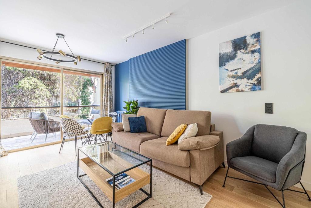 un salon avec un canapé et une table dans l'établissement LE FLEURI avec terrasse, à côté du Martinez, idéal pour un séjour plaisant, à Cannes
