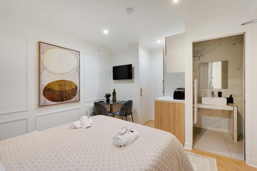 - une chambre blanche avec un lit et une salle de bains dans l'établissement Charming studio -2P- Canal Saint-Martin, à Paris