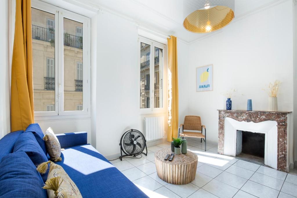 un salon avec un canapé bleu et une cheminée dans l'établissement SAINTE - Vieux Port - Opéra, à Marseille