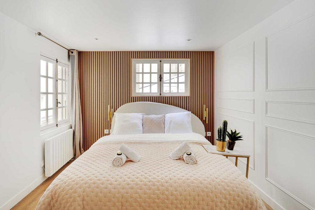 une chambre avec un grand lit avec deux serviettes dessus dans l'établissement Modern studio - 2P - Canal Saint Martin, à Paris