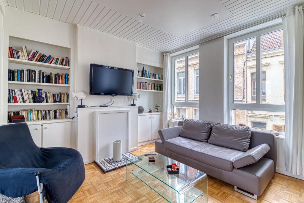 un salon avec un canapé et une télévision dans l'établissement Le Majestin - Appt 6p Calais centre, à Calais