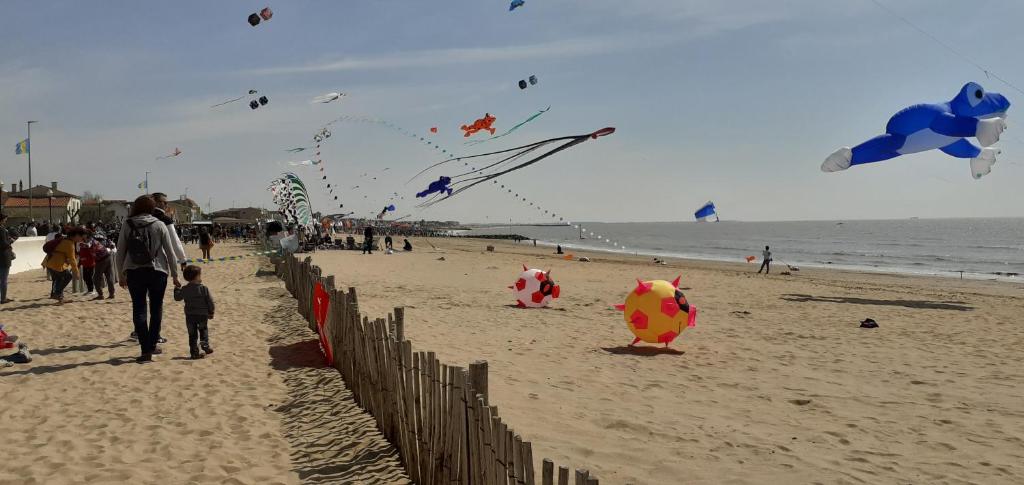 Un groupe de gens sur la plage volant des cerfs-volants dans l'établissement Appartement léonard, à Châtelaillon-Plage