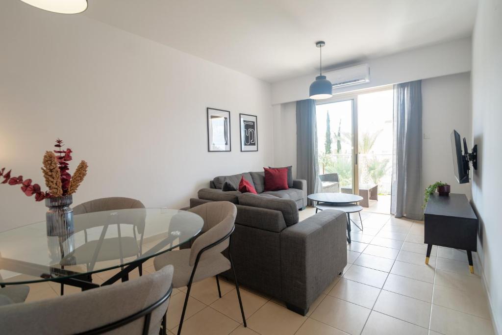 a living room with a couch and a glass table at Phaedrus Living Paphos Elysian Escape in Paphos