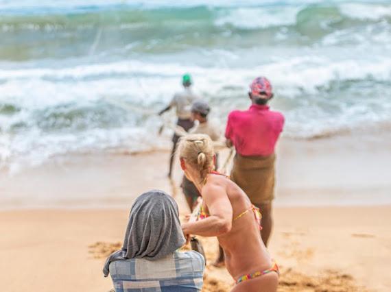 a group of people playing on the beach at Frangipani Beach Villa in Tangalle