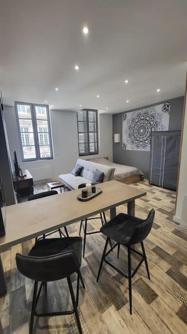 un salon avec une table, des chaises et un canapé dans l'établissement Studio coeur de ville historique, à Tonnerre