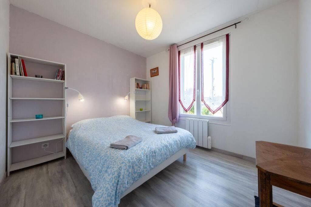 Una habitación blanca con una cama y una ventana en La Raboliote -Maison 3 chambres- jardin - 15 min Parc Fédéral Lamotte - CAUTION OBLIGATOIRE, en Brinon-sur-Sauldre