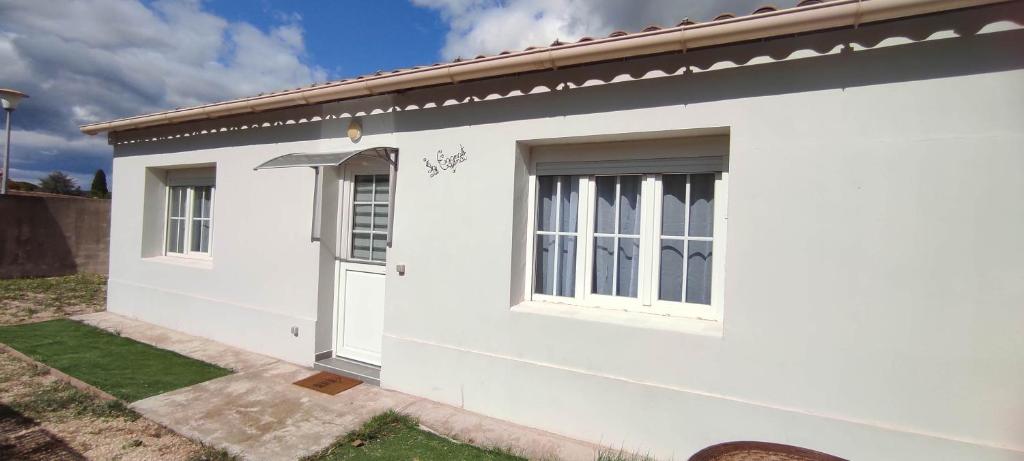 une maison blanche avec une porte et des fenêtres dans l'établissement Maison Cagnat, à Pierrelatte