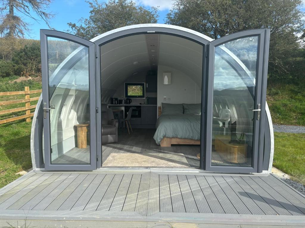 una camera da letto in una tenda a cupola con porte scorrevoli in vetro di Sky High Glamping a Shillelagh