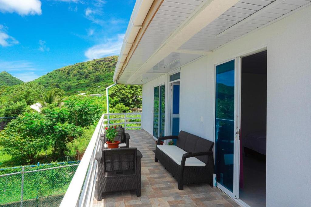 a porch with a couch and a chair on a balcony at Old Providence Paradise View in Providencia