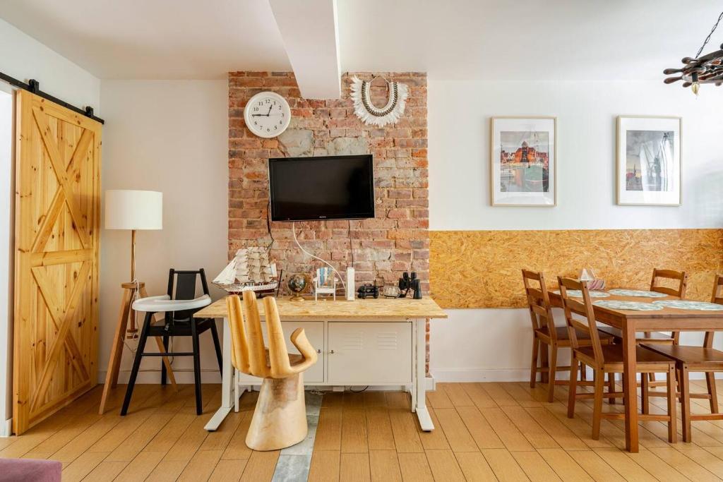 a kitchen with a brick wall and a table and chairs at Apartament Gdańsk Park Śródmieście in Sidlice