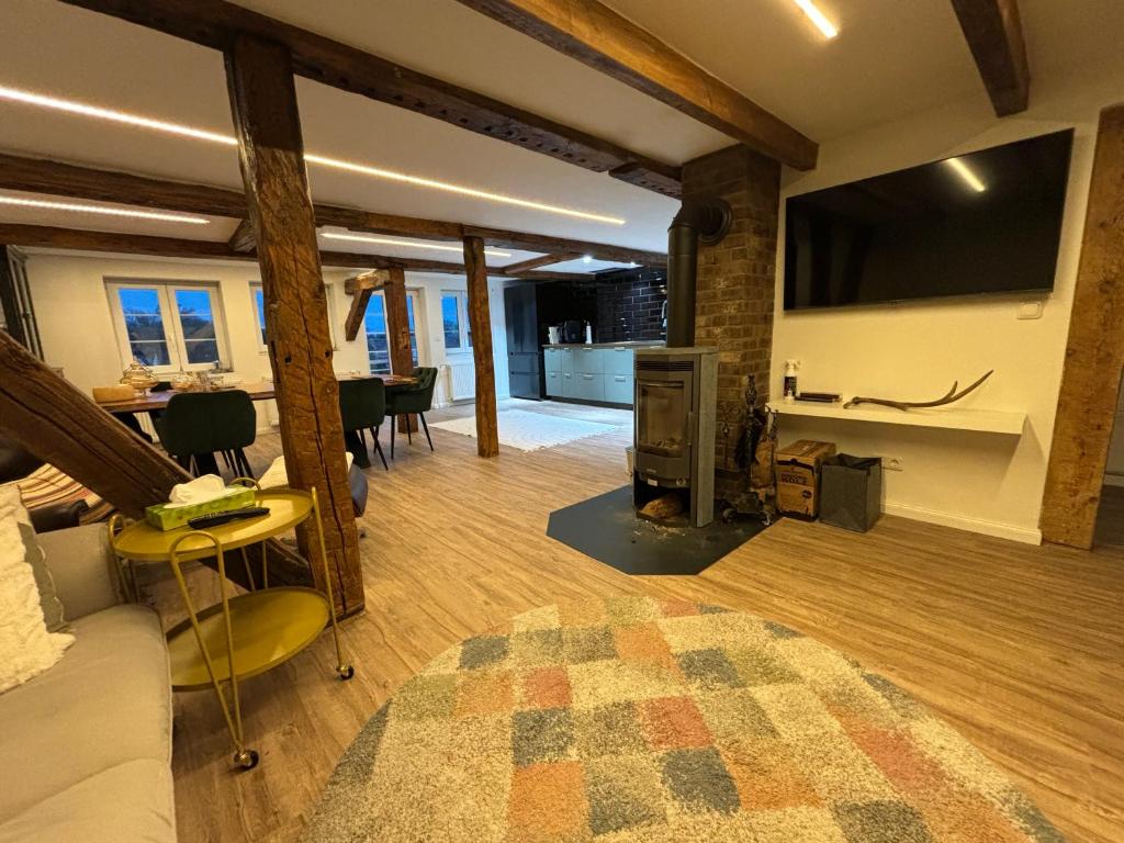 a living room with a couch and a tv on a wall at Modernes Stadtwohnen im charmanten Fachwerk, Mindestaufenthalt 3 Tage in Plau am See