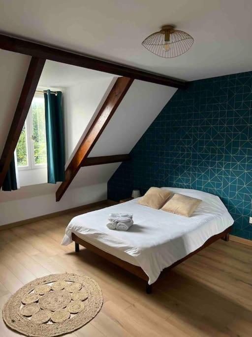 une chambre avec un lit avec un mur bleu dans l'établissement Logement avec parking Cité Médiévale, à Provins