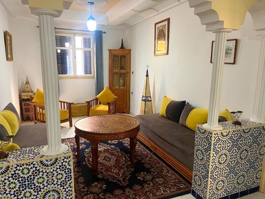 una sala de estar con un sofá y una mesa en Abdallah Appartement, en Essaouira