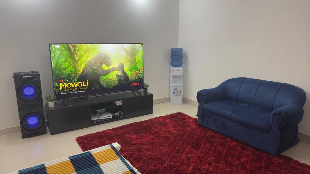 Una sala de estar con un sofá y un televisor. en Naimz short stay Apartment, en Abu Dabi