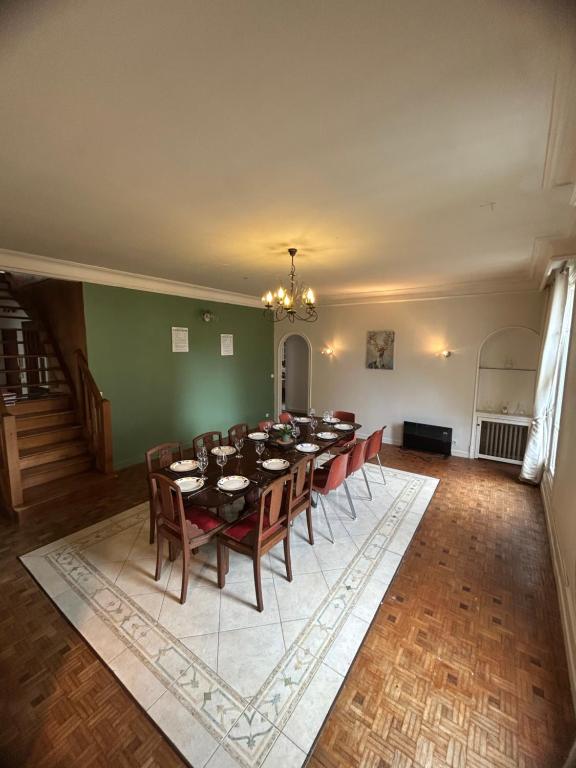 una grande sala da pranzo con un lungo tavolo e sedie di Appartement 6 Chambres Coeur de Ville a Soissons