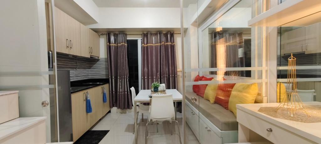 - une petite cuisine avec une table et un lit dans l'établissement The Cozy Rosy - SMDC Winds Staycation, à Tagaytay