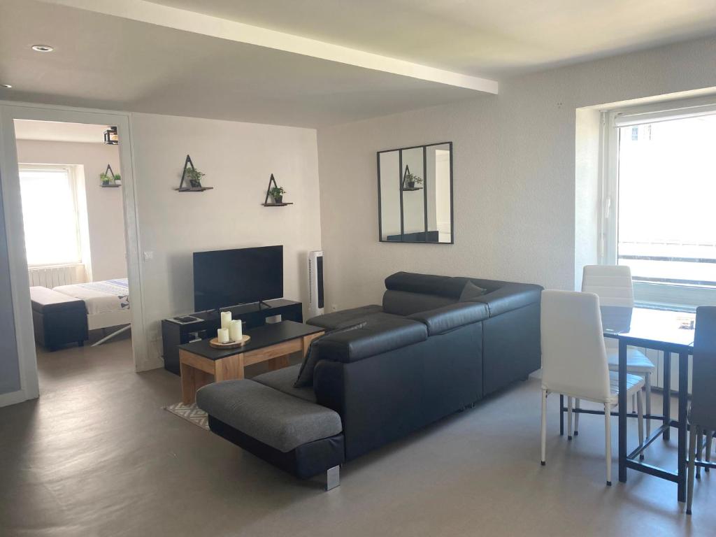 un salon avec un canapé bleu et une table dans l'établissement Grand T2 centre-ville, calme, lumineux et spacieux, 1 chambre, 1 à 5 pers, climatisation, wifi, parking libre et gratuit, à Lorient