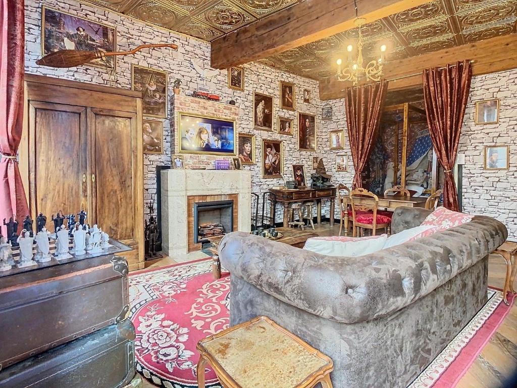 un salon avec un canapé et une cheminée dans l'établissement Le Monde Magique - Harry Potter - Hypercentre, à Grenoble