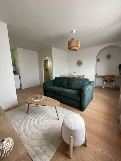 un salon avec un canapé vert et une table dans l'établissement Opale plage, à Dunkerque