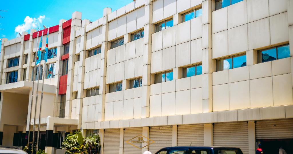 ein großes Gebäude mit roter und weißer in der Unterkunft Hotel New Riviera bukavu in Bukavu