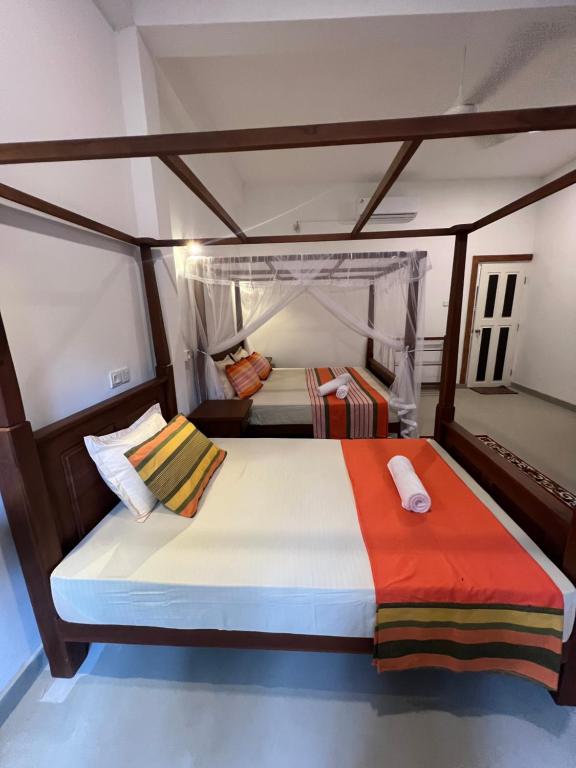 Postel nebo postele na pokoji v ubytování TEMBO Cottage Wilpattu