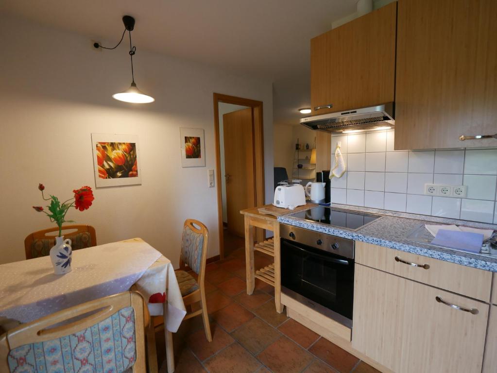 a kitchen with a stove and a table with a tableablish at Ferienhof Nonnevitzer Strand, Typ B in Dranske
