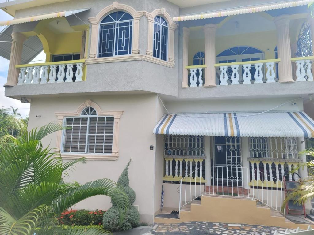 a large white house with a balcony at Palm Breeze Villa JM in Lucea