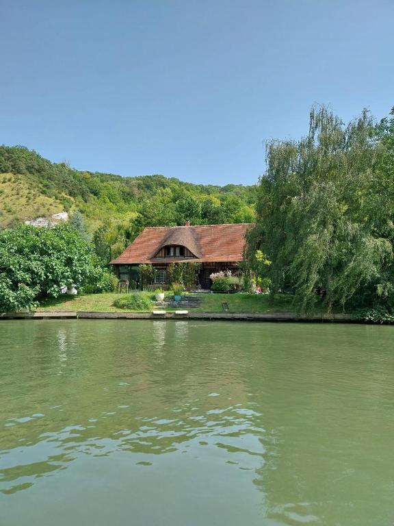 une maison sur la rive d'un lac avec une maison dans l'établissement Maison au bord de la Seine, à Vatteville