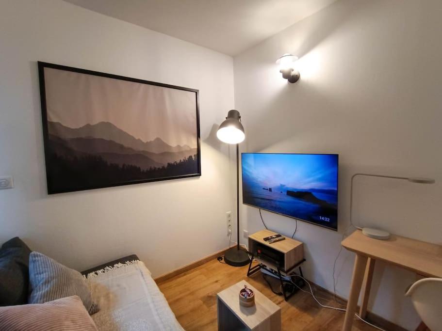 un salon avec une grande télévision à écran plat au mur dans l'établissement Studio calme et lumineux près de la gare, à Toulouse