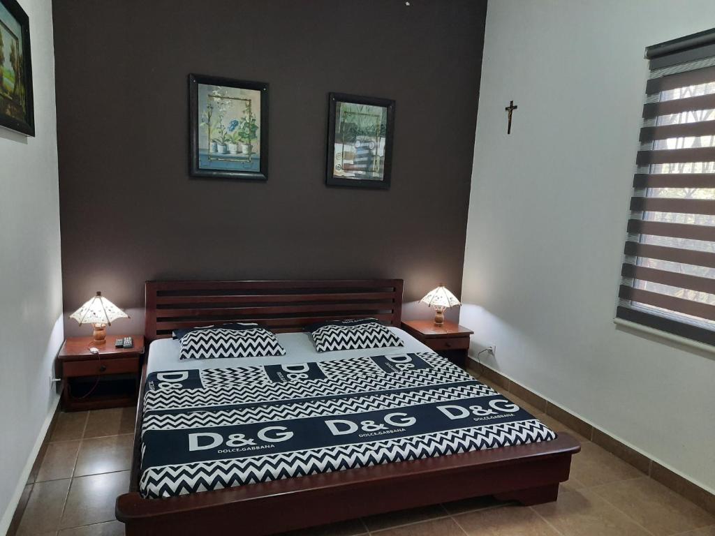 - une chambre avec un lit et 2 tables avec des lampes dans l'établissement Appartement Centre ville Antalaha, à Antalaha