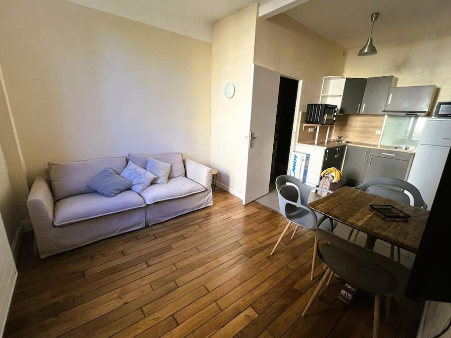 un salon avec un canapé et une table dans l'établissement Appartement Pierre Marty T2 centre-ville Aurillac, à Aurillac