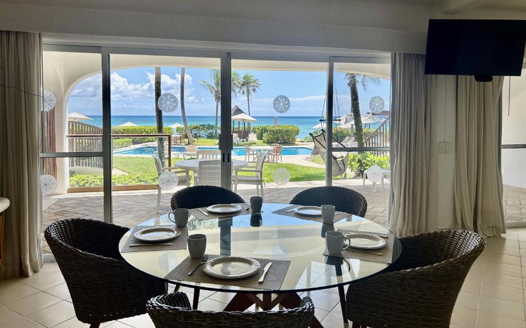a dining room table with chairs and a view of the ocean at Las Villas Akumal in Akumal