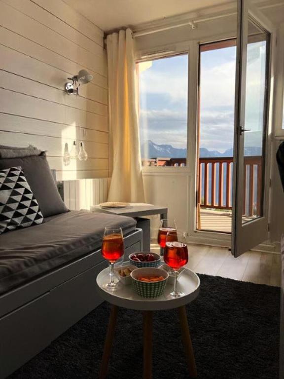 - un salon avec une table et deux verres de vin dans l'établissement Résidence L'Ours Blanc - maeva Home - Appartement 3 pièces 6 personnes - Exclusive - super Home MAE-5741, à Huez