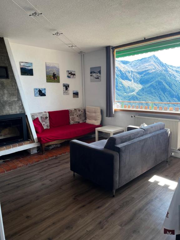 un salon avec un canapé et une grande fenêtre dans l'établissement Orcières Merlette, à Orcières