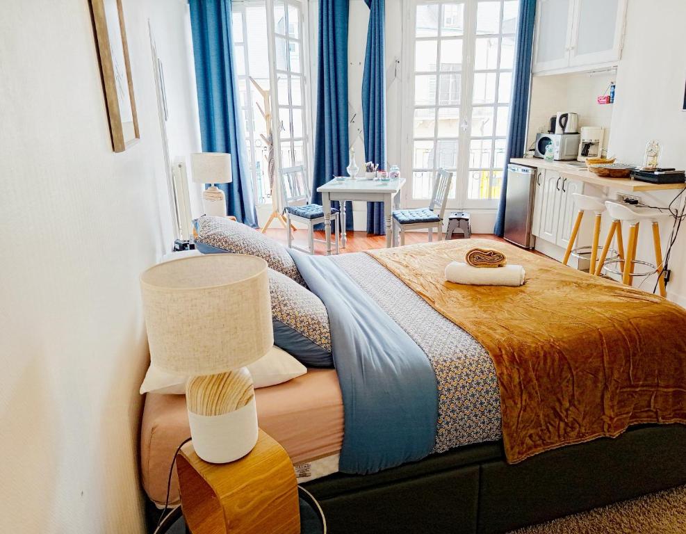 une chambre avec un lit et une table avec une lampe dans l'établissement Le magnifique en plein centre historique, au Mans