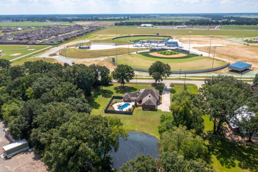 an aerial view of a park with a tent and a pond at Gameday Getaway - Pool - King Bed - Sports Complex in Youngsville