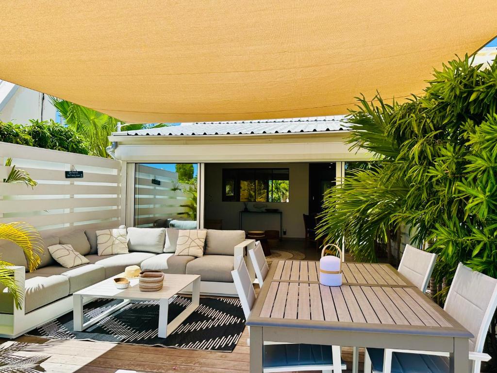 a patio with a couch and a table at Shell Beach Splendide 2 chambres sur la plage in Baie Nettle