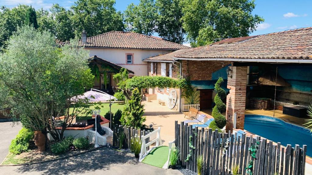 a house with a fence and a swimming pool at Chambres d'Hôtes Au Clos Saint Georges in Saint-Jory