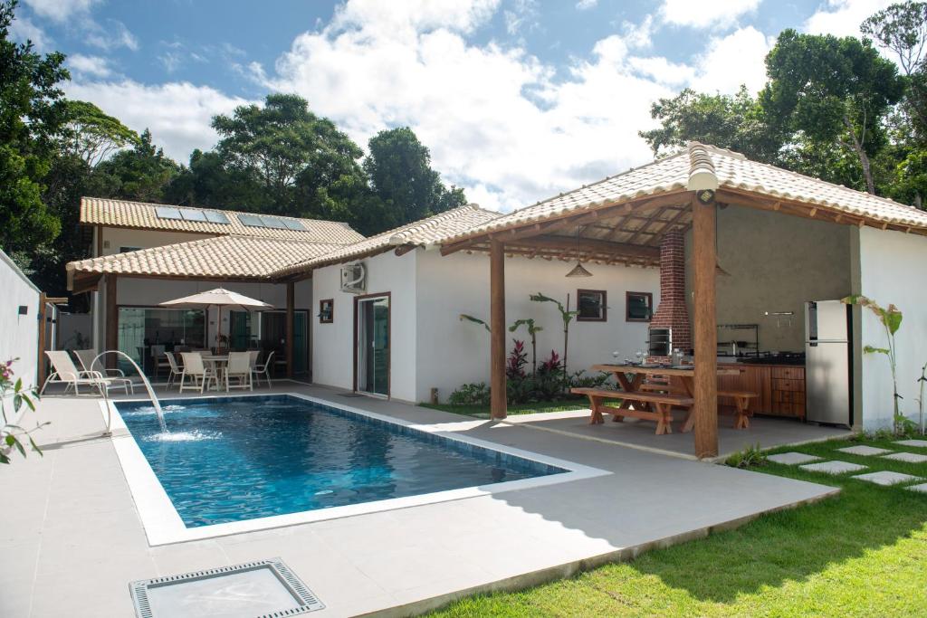 ein Haus mit einem Swimmingpool im Hof in der Unterkunft Residencial Falésias de Pitinga in Arraial d'Ajuda