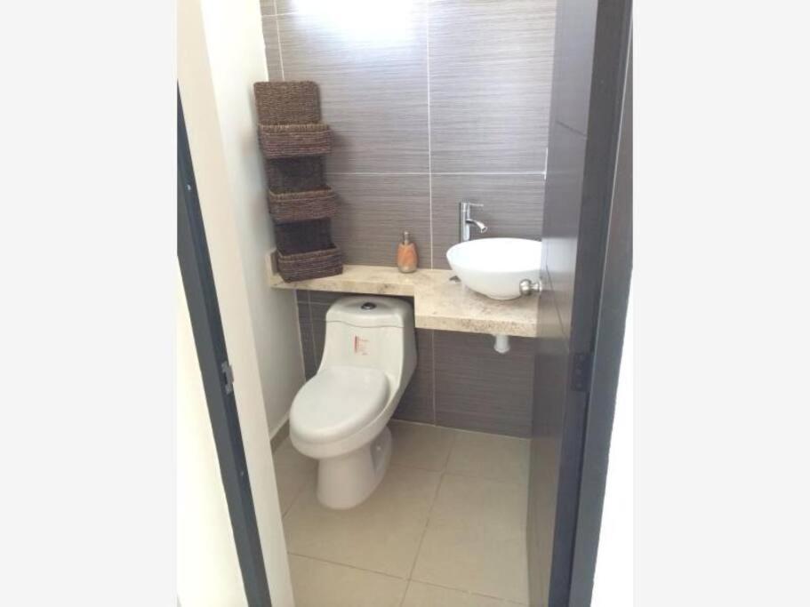 a small bathroom with a toilet and a sink at Casa en fraccionamiento con seguridad y 2 casas club con alberca se Factura in Santa Gertrudis