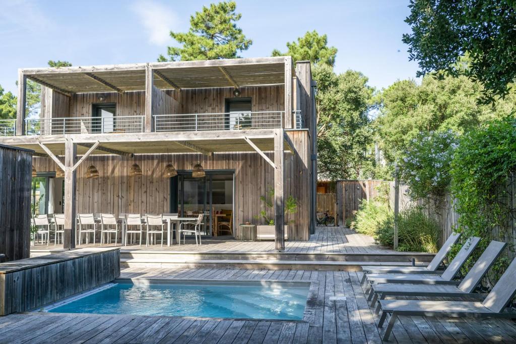a house with a swimming pool and a deck at Villa Contis Plage in Lit-et-Mixe